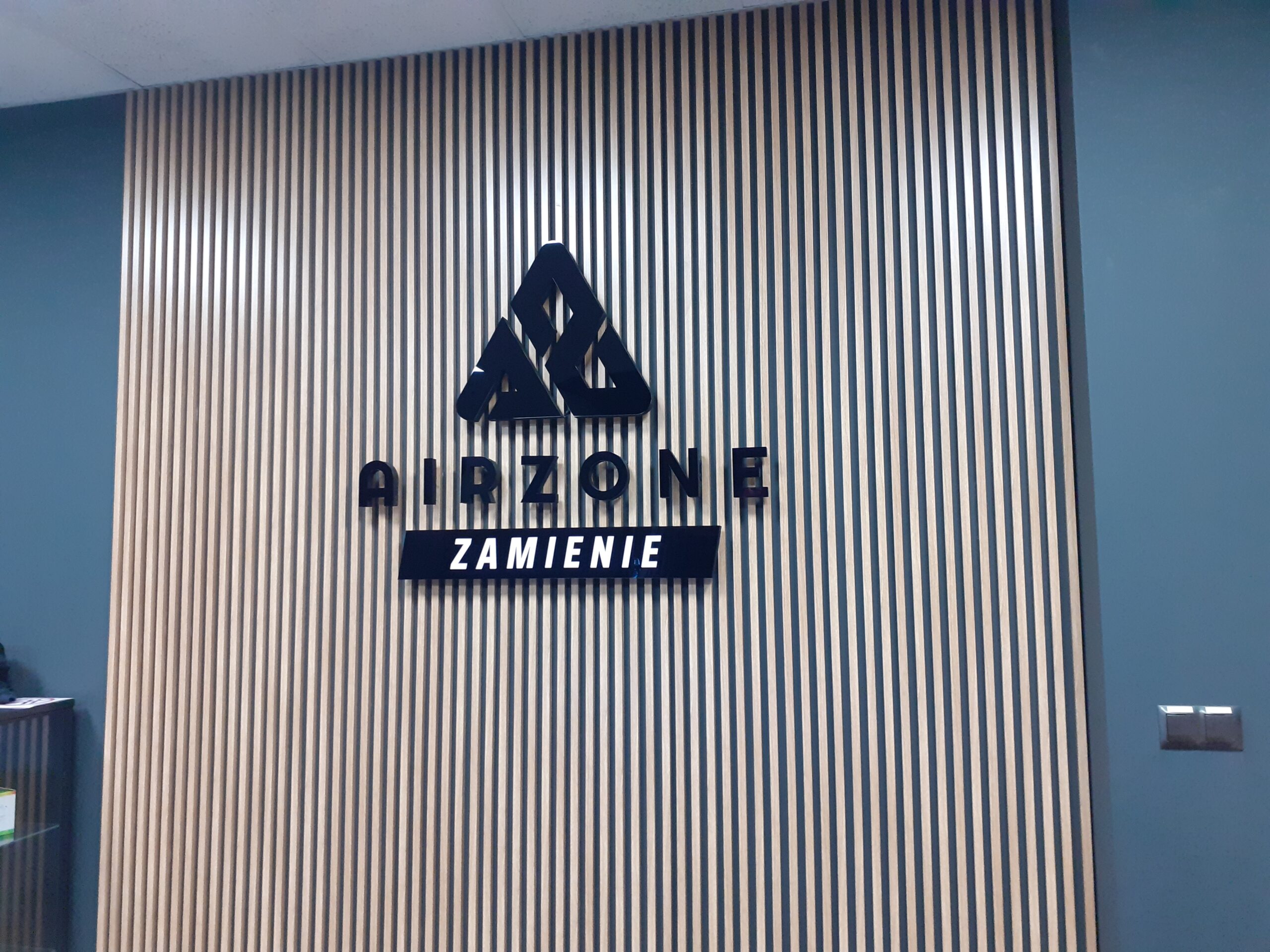 Czarne litery przestrzenne Airzone w recepcji - realizacja Designpol